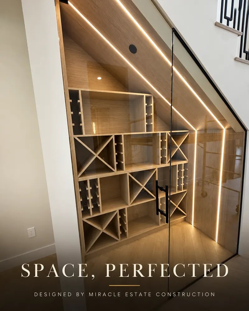 Built-in wine rack with glass door and warm LED strip lighting tucked under a staircase